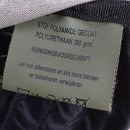 Close-up of a care label inside the Dutch Army Woodland Daypack showing material and cleaning instructions.