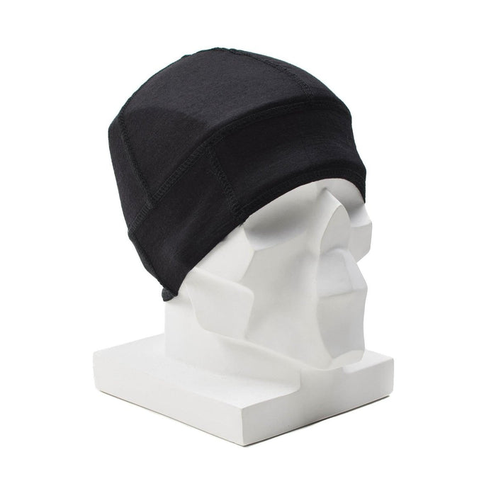 Gorro de lana merino de estilo militar negro exhibido sobre una cabeza de maniquí geométrico blanco para uso en exteriores.