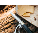 Magnum Bon Appetite pocket knife with wooden handle and 440A steel blade next to sliced cheese on wooden surface
