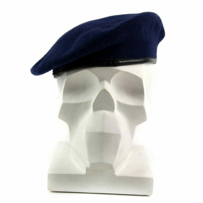 Boina de lana del ejército alemán de color azul oscuro con ribete de cuero expuesta en una cabeza de maniquí blanca.