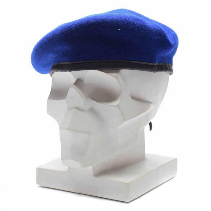 Auténtica boina de lana azul real militar alemana sobre una cabeza de maniquí blanca con banda de cuero negro.
