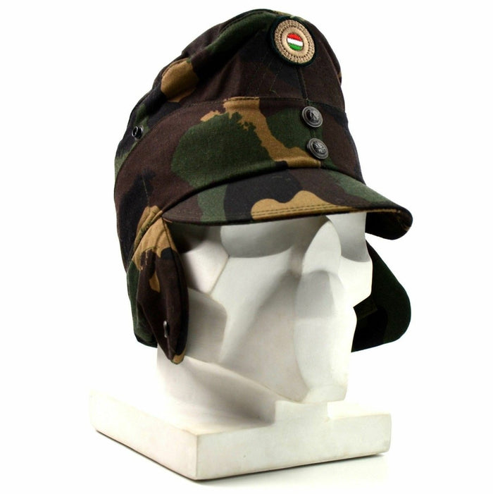 Gorra de invierno militar de camuflaje húngaro con solapa en el cuello y la insignia de la bandera nacional en el frente mostrada en una cabeza de maniquí blanca