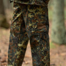 Close-up of German military style flecktarn camo cargo pants with multiple pockets in a forest setting