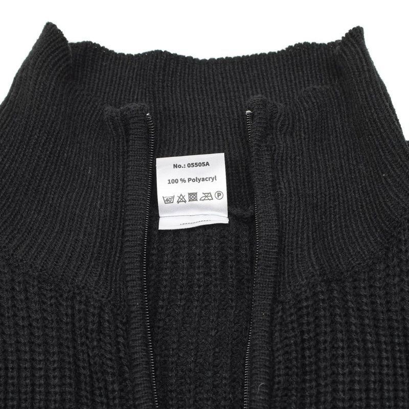 Black knit sweater with a label on a white background