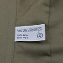 Close-up of care label on olive Austrian army M65 lightweight short sleeve combat shirt showing fabric and washing instructions