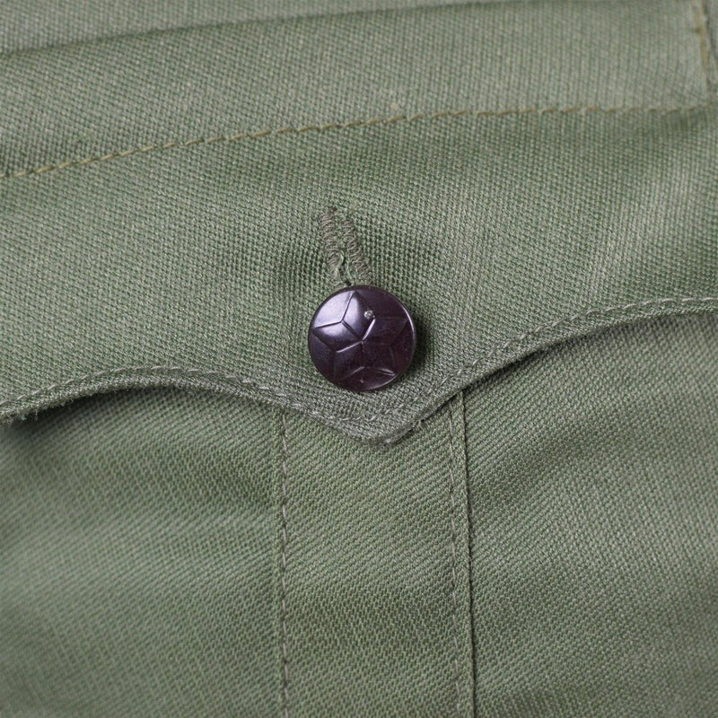 Close-up of a black star-embossed button on the original Bulgarian army green olive military jacket pocket flap