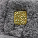 Close-up of gold-toned Czech Republic coat of arms insignia on gray faux fur winter military hat.