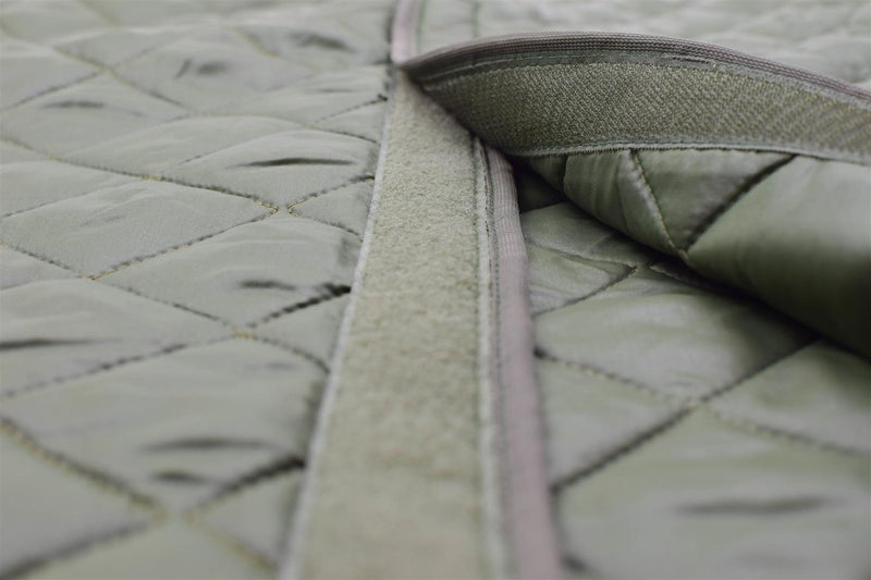 Close-up of olive green quilted liner with Velcro fastening designed for Swedish military parka jackets.