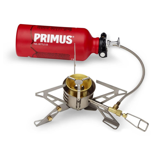 Estufa de camping multicombustible Primus OmniFuel II con botella de combustible roja y quemador trípode plegable para cocinar al aire libre.