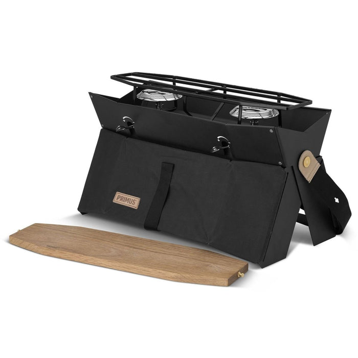 Estufa de camping compacta Primus Onja de dos quemadores con diseño plegable y parabrisas de madera para cocinar al aire libre.