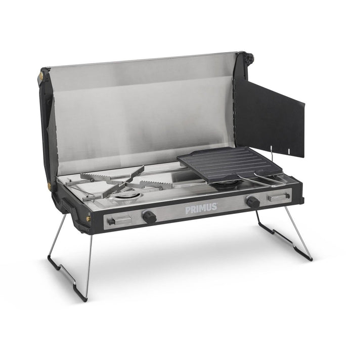 Estufa de camping para exteriores Primus Tupike con dos quemadores de gas, patas plegables y plancha antiadherente para cocinar de forma versátil.