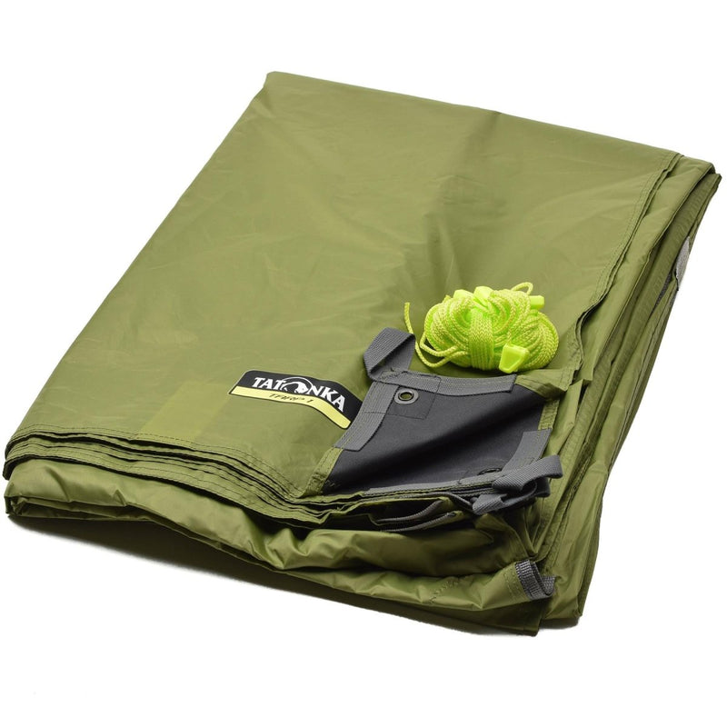 Folded olive green Tatonka waterproof tent trap shelter with attached bright green guy rope for outdoor use.
