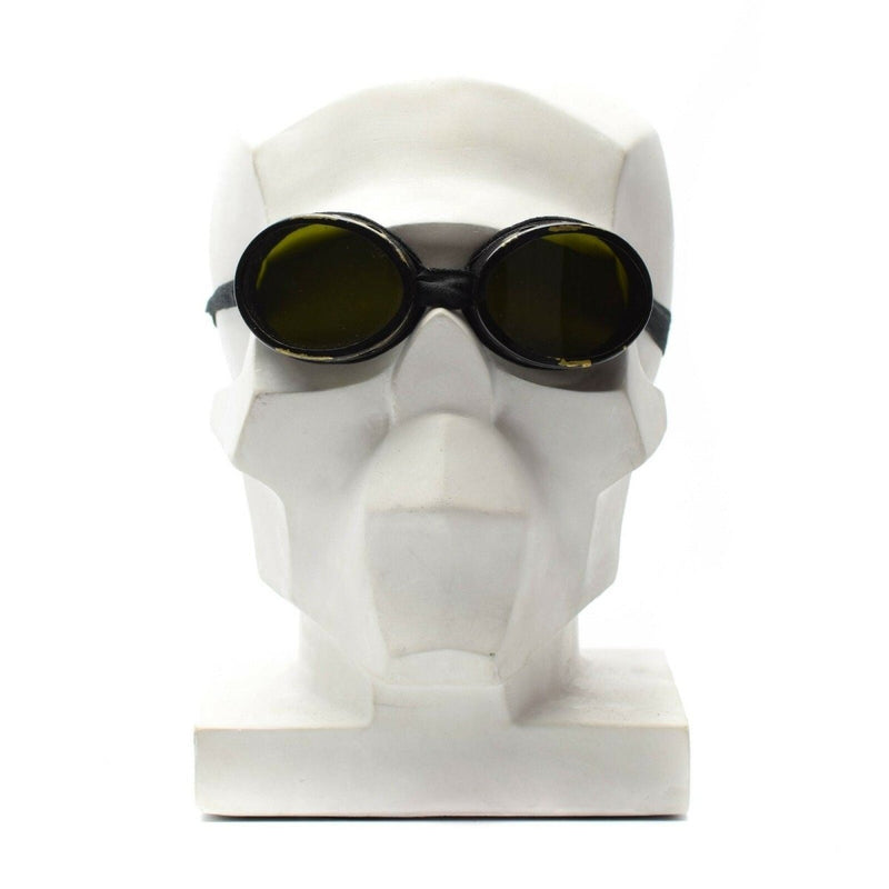 WWII genuine Swiss army mountain round helmet goggles with dark protective lenses on a white mannequin head.